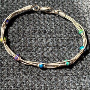 Clever bracelet made from real guitar strings. Bracelet is 7 inches long.